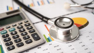 Stethoscope with calculator on chart graph paper, finance, accou